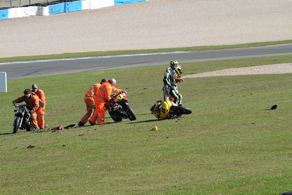 Riders walk away as marshals recover the bikes